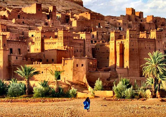 A human figure dressed in blue juxtaposed against traditional Moroccan architecture in the distance
