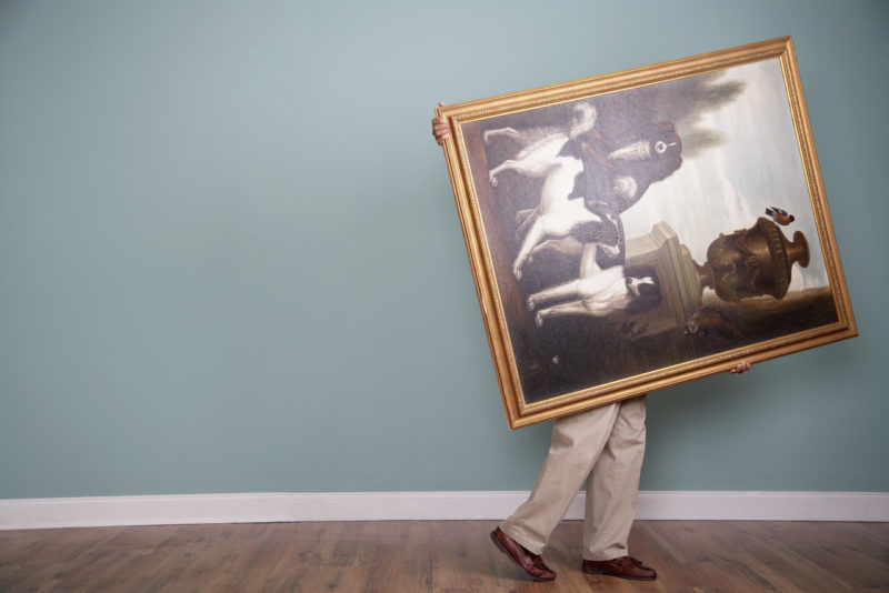 Man Carrying A Large Painting