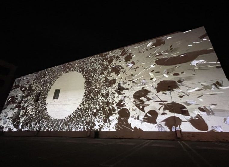 Digital art projected on a large wall outside