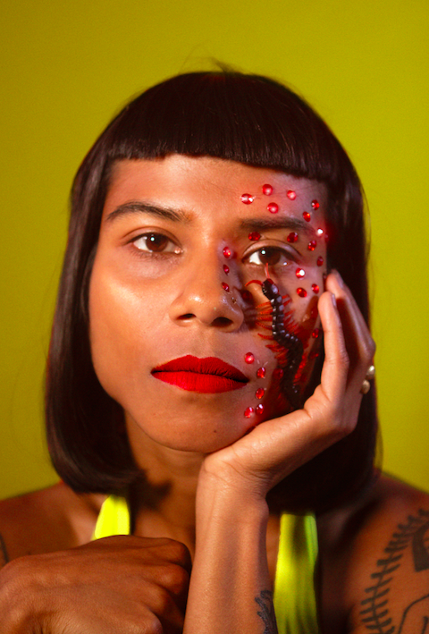 Headshot of Opashona Gosh against a dark yellow background