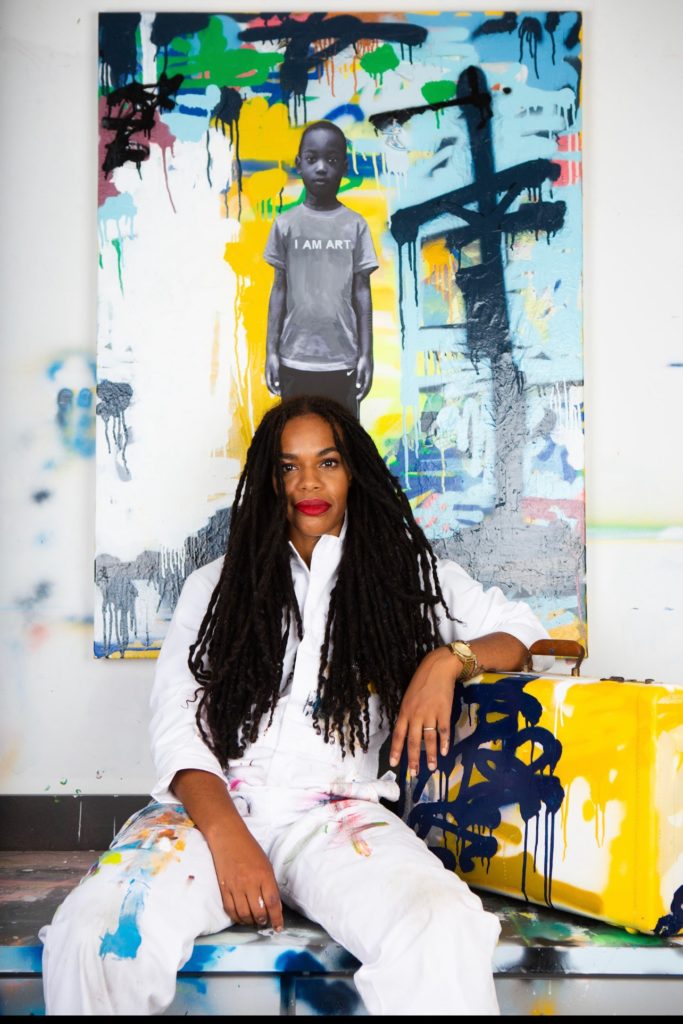 Blu Murphy seated in front of a colorful painting