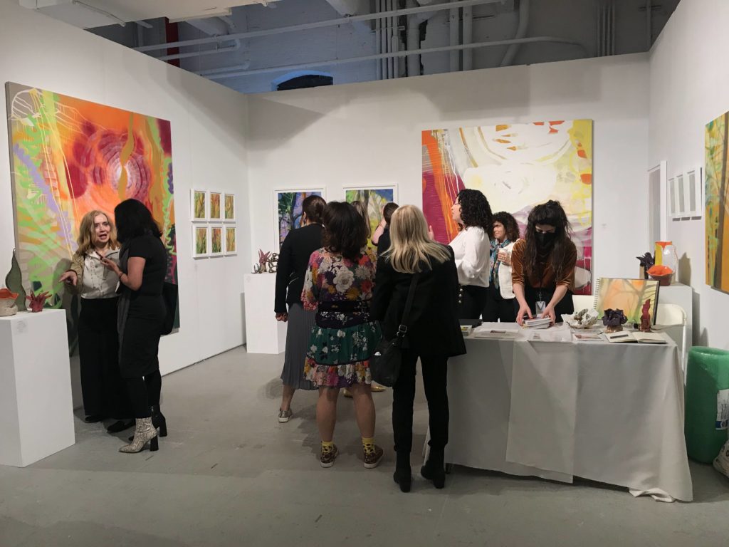 A group explores the interior of a booth at an art fair