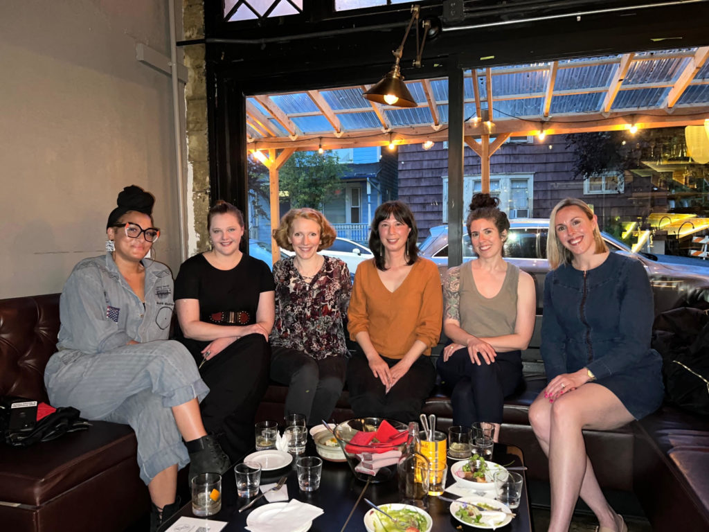 6 women pose for a seated photo