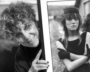 Alice Sachs Zimet smiling around the side of a black and white photograph