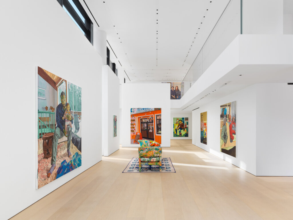 Two chairs in gallery with paintings in the background