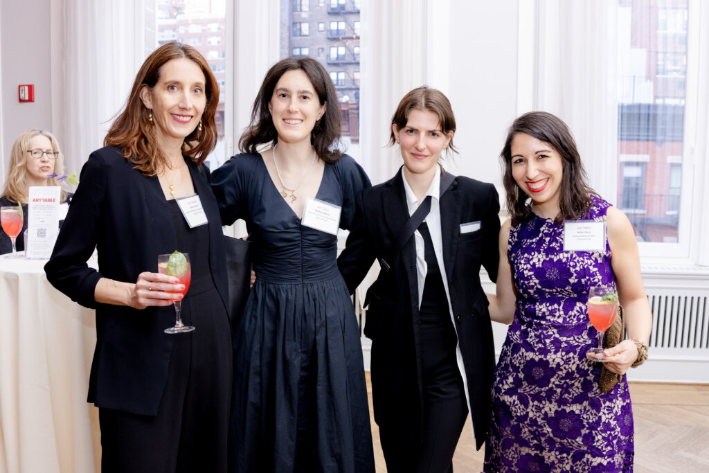 Four women holding wine glasses.
