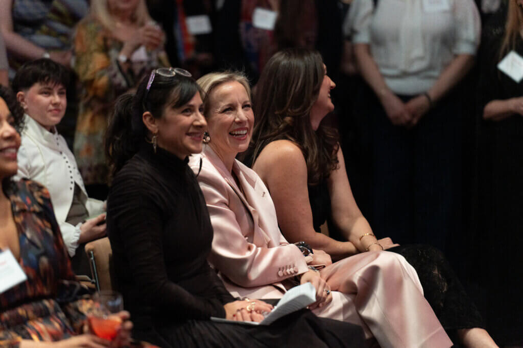 2 women seated smiling at something off camera