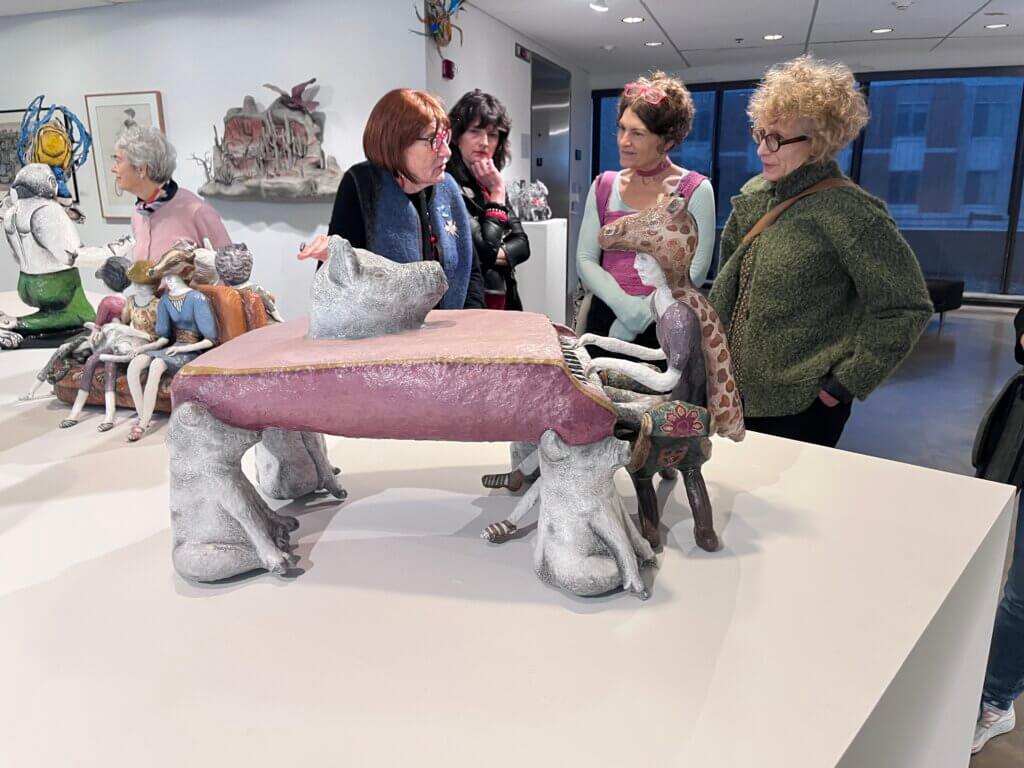 Joan Danziger talking to program attendees behind a piece of her work.