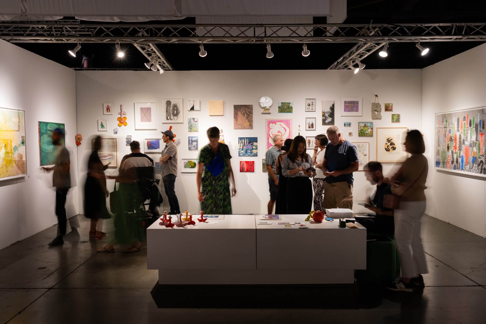 Image of many people in a fair booth looking at art at the Seattle Art Fair 2025