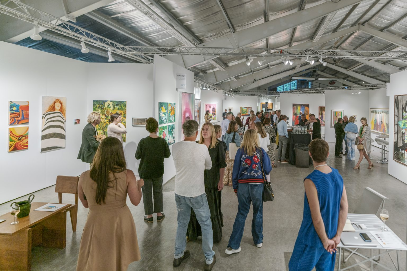 image of many people walking through intersect aspen art fair between the booths looking at various art